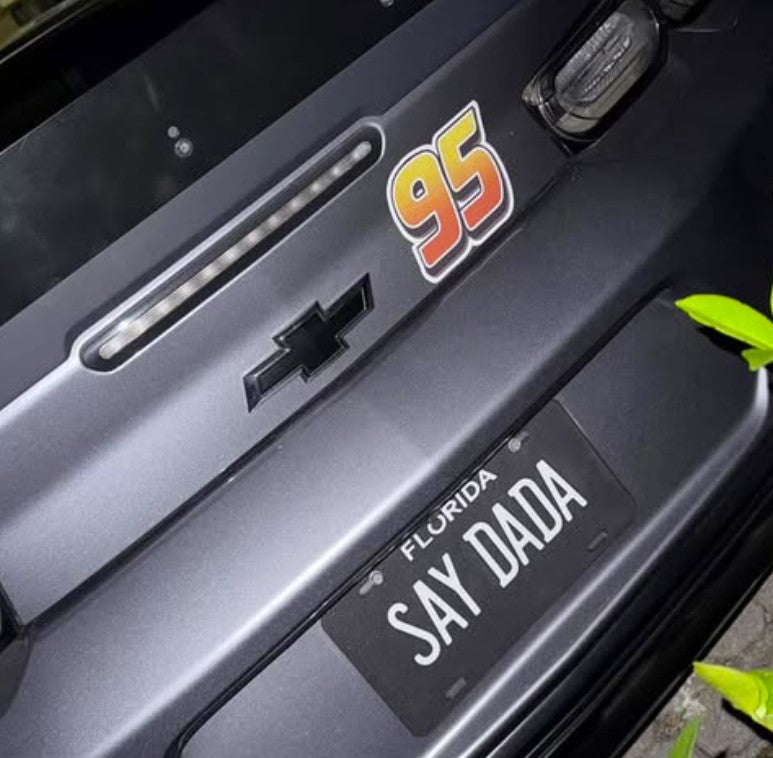 Close-up of a car with '95' badge and 'SAY DADA' license plate.