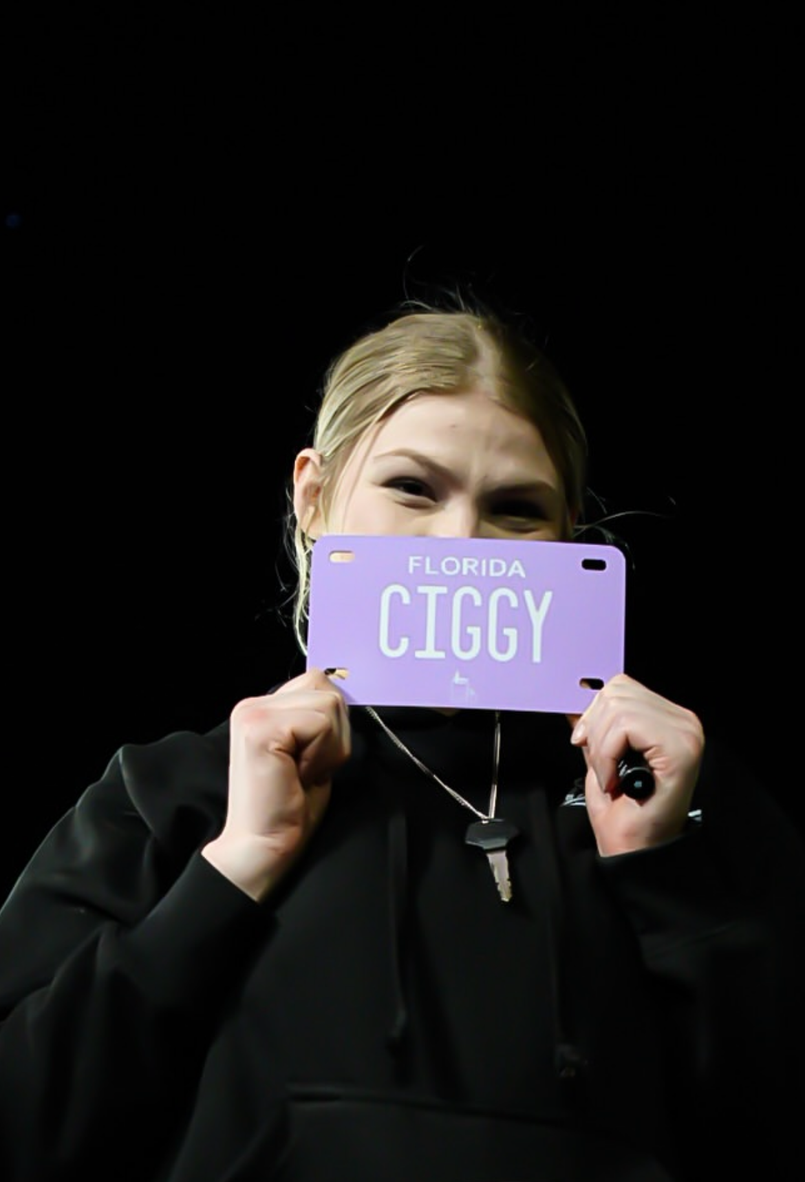 Custom motorcycle vanity plate, lavender and white with text "ciggy"
