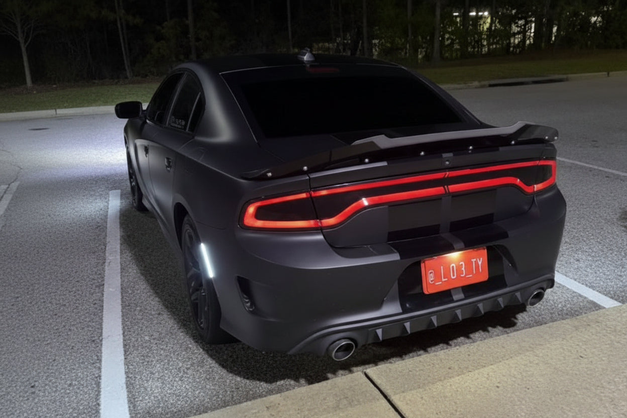 Black car with red taillights in a parking lot at night with a magnetic plate of their IG tag